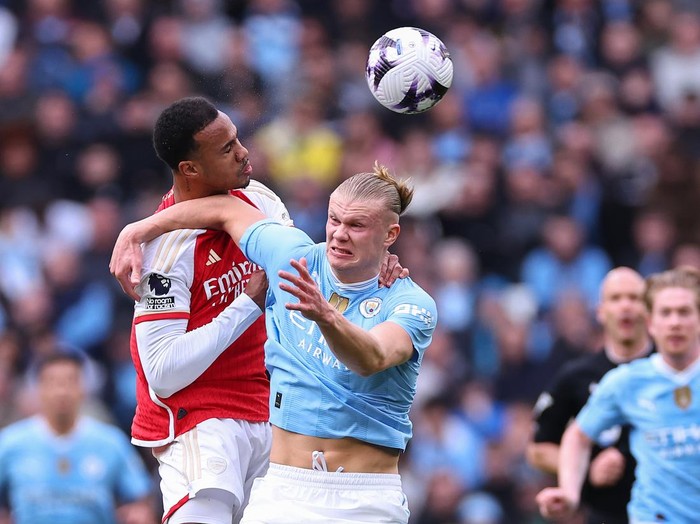 MANCHESTER, ENGLAND - MARCH 31: William Saliba of Arsenal wins a header against Erling Haaland of Manchester City during the Premier League match between Manchester City and Arsenal FC at Etihad Stadium on March 31, 2024 in Manchester, England.(Photo by Robbie Jay Barratt - AMA/Getty Images)