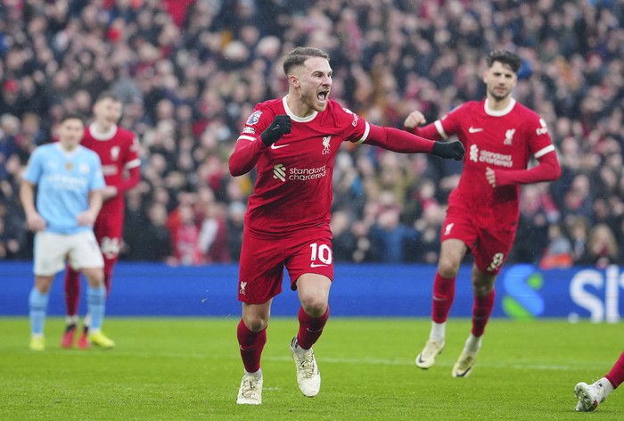 Liverpools Alexis Mac Allister celebrates after scoring a penalty, his sides first goal during the English Premier League soccer match between Liverpool and Manchester City, at Anfield stadium in Liverpool, England, Sunday, March 10, 2024. (AP Photo/Jon Super)