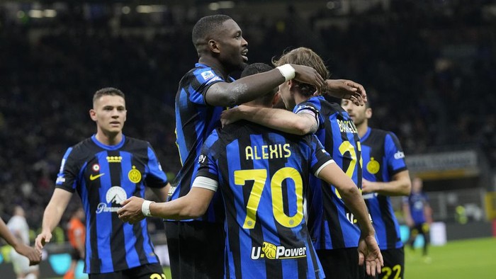 Inter Milans Alexis Sanchez, centre, celebrates after scoring his sides second goal during the Serie A soccer match between Inter Milan and Empoli at the San Siro Stadium, in Milan, Italy, Monday, April 1, 2024. (AP Photo/Antonio Calanni)