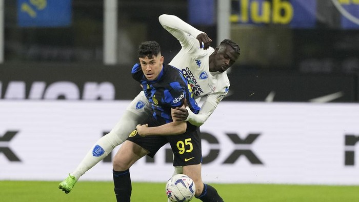Inter Milans Alessandro Bastoni is challenged by Empolis Mbaye Niang, rear, during the Serie A soccer match between Inter Milan and Empoli at the San Siro Stadium, in Milan, Italy, Monday, April 1, 2024. (AP Photo/Antonio Calanni)