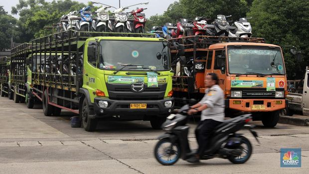 Pekerja mengecek ikatan kendaraan motor yang mana hendak dikirim melalui jasa pengiriman yang tersebut dibuka untuk Mudik Gratis 2024 pada Terminal Pulogadung, Jakarta, Rabu (3/4/2024). (CNBC Indonesia/Muhammad Sabki)
