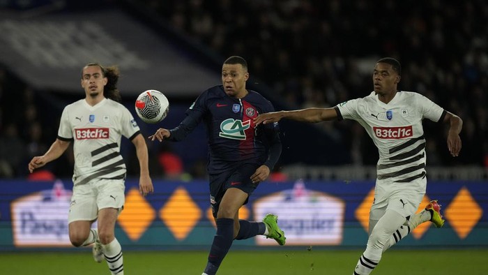 PSGs Kylian Mbappe, is challenged by Rennes Warmed Omari, right, and Rennes Arthur Theate during the French Cup semifinal soccer match between Paris Saint-Germain and Rennes at the Parc des Princes stadium in Paris, France, Wednesday, April 3, 2024. (AP Photo/Thibault Camus)