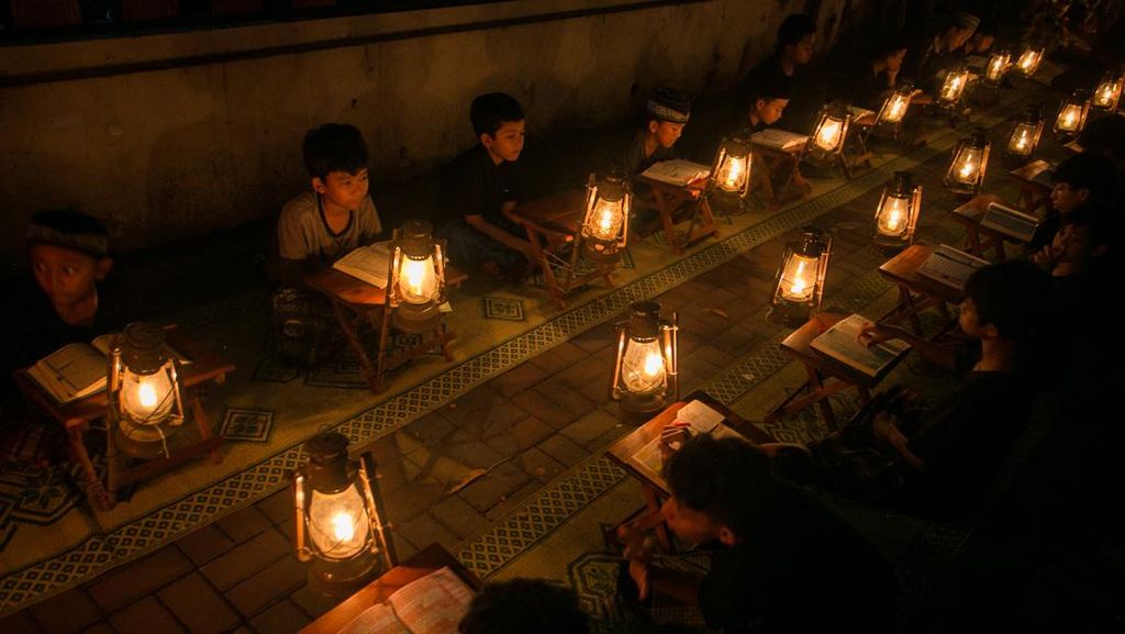 Momen Syahdu Baca Al-Quran dengan Penerangan Lilin