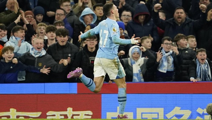 Manchester City's Phil Foden runs towards the fans as he celebrates after scoring his team's fourth goal and his own third of the match during the English Premier League soccer match between Manchester City and Aston Villa at the Etihad Stadium in Manchester, England, Wednesday, April 3, 2024. (AP Photo/Dave Thompson)