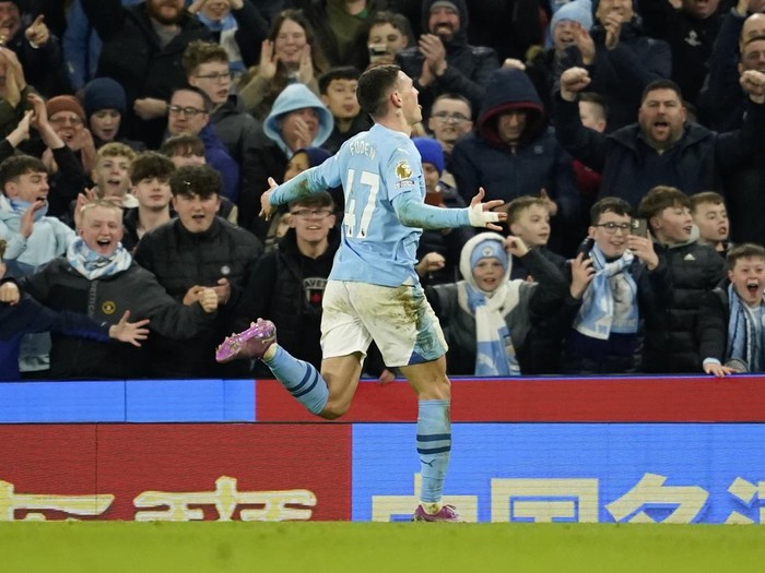 Manchester Citys Phil Foden runs towards the fans as he celebrates after scoring his teams fourth goal and his own third of the match during the English Premier League soccer match between Manchester City and Aston Villa at the Etihad Stadium in Manchester, England, Wednesday, April 3, 2024. (AP Photo/Dave Thompson)