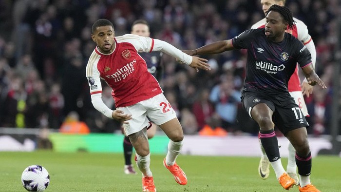 Arsenals Reiss Nelson, left, challenges for the ball with Luton Towns Pelly Ruddock Mpanzu during the English Premier League soccer match between Arsenal and Luton Town at the Emirates Stadium, London, Wednesday, Apr. 3, 2024. (AP Photo/Frank Augstein)