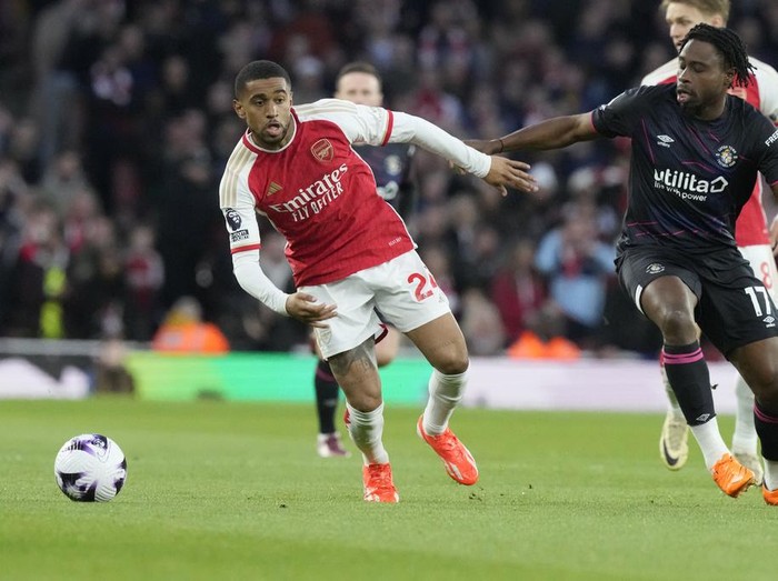Arsenal's Reiss Nelson, left, challenges for the ball with Luton Town's Pelly Ruddock Mpanzu during the English Premier League soccer match between Arsenal and Luton Town at the Emirates Stadium, London, Wednesday, Apr. 3, 2024. (AP Photo/Frank Augstein)