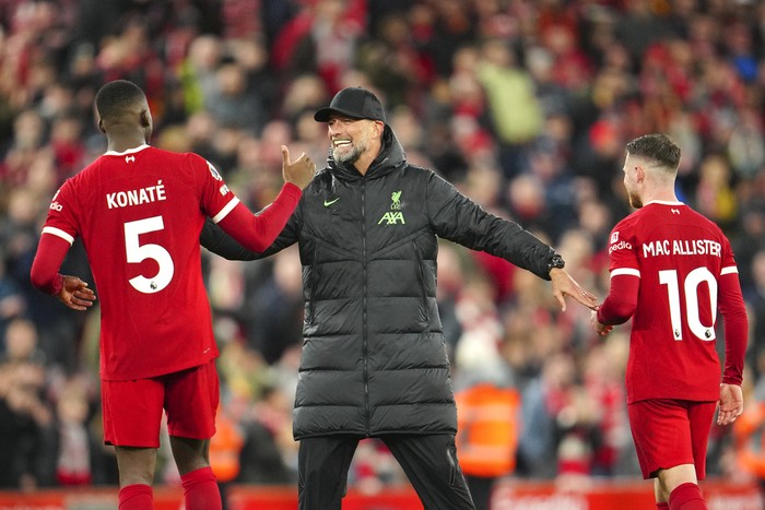 Liverpool's manager Jurgen Klopp celebrates with Liverpool's Ibrahima Konate, left, and Liverpool's Alexis Mac Allister at the end of the English Premier League soccer match between Liverpool and Sheffield United at the Anfield stadium in Liverpool, England, Thursday, Apr. 4, 2024. (AP Photo/Jon Super)