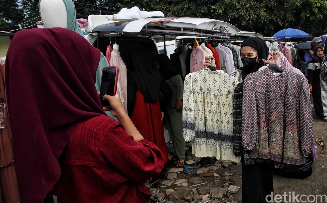 Pedagang memilih baju di Pasar Tasik.
