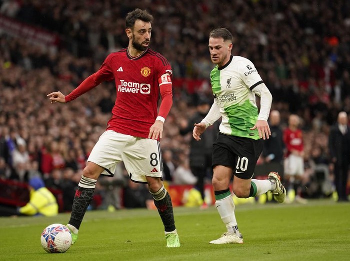 Manchester Uniteds Bruno Fernandes, left, is challenged by Liverpools Alexis Mac Allister during the FA Cup quarterfinal soccer match between Manchester United and Liverpool at the Old Trafford stadium in Manchester, England, Sunday, March 17, 2024. (AP Photo/Dave Thompson)