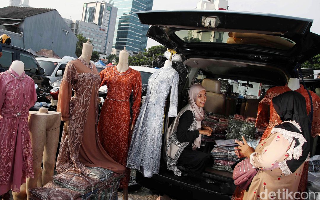 Potret pedagang menjajakan barang dagangannya dari bagasi mobil.