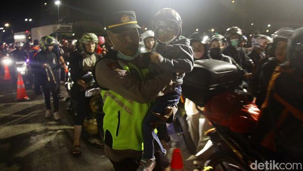 Momen Petugas Bantu Pemudik Balita Masuk Kapal