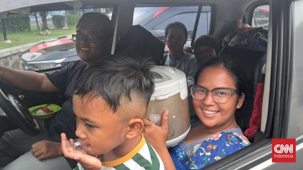 Helena Dwi (38), pemudik asal Bekasi, Jawa Barat dengan tujuan Wonosobo, Jawa Tengah membawa magic com atau penanak nasi berkapasitas 1,5 liter untuk bekal makan selama perjalanan mudik Lebaran 2024. CNN Indonesia/Poppy Fadhilah