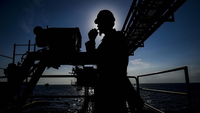 Energi di bulan suci dari Pulau Besi Pekerja berkoordinasi lewat walkie talkie di kepraktisan buatan anjungan lepas pantai Sepinggan Field, Kalimantan Timur.