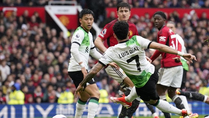 Liverpools Luis Diaz, centre, scores the opening goal during the English Premier League soccer match between Manchester United and Liverpool at the Old Trafford stadium in Manchester, England, Sunday, April 7, 2024. (AP Photo/Dave Thompson)