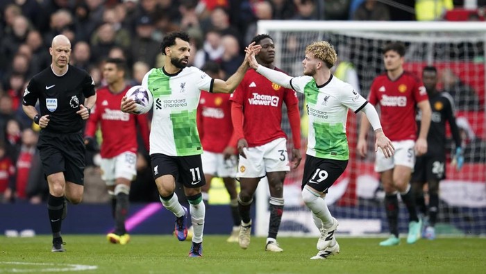 Liverpools Mohamed Salah, centre left, celebrates with Harvey Elliott after scoring his sides second goal during the English Premier League soccer match between Manchester United and Liverpool at the Old Trafford stadium in Manchester, England, Sunday, April 7, 2024. (AP Photo/Dave Thompson)