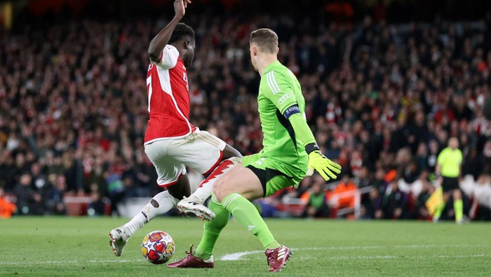 LONDON, ENGLAND - APRIL 9:  Bukayo Saka of Arsenal  collides with Manuel Neuer of Bayern Munich towards the end of  the UEFA Champions League quarter-final first leg match between Arsenal FC and FC Bayern Munchen at Emirates Stadium on April 9, 2024 in London, England.(Photo by Catherine Ivill - AMA/Getty Images)
