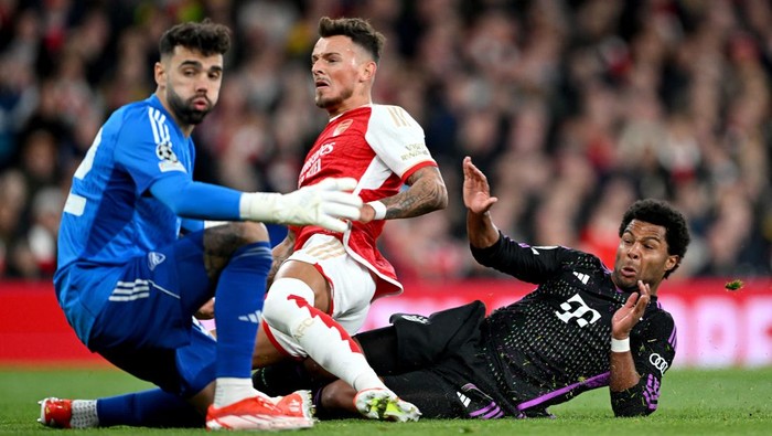 LONDON, ENGLAND - APRIL 09: Serge Gnabry of Bayern Munich looks on as he scores his teams first goal under pressure from David Raya and Ben White of Arsenal during the UEFA Champions League quarter-final first leg match between Arsenal FC and FC Bayern München at Emirates Stadium on April 09, 2024 in London, England. (Photo by Shaun Botterill/Getty Images)