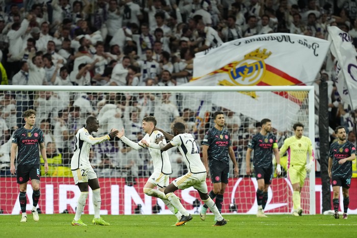 Real Madrids Federico Valverde, third left, celebrates with his teammates after scoring his sides third goal during the Champions League quarterfinal first leg soccer match between Real Madrid and Manchester City at the Santiago Bernabeu stadium in Madrid, Spain, Tuesday, April 9, 2024. (AP Photo/Jose Breton)