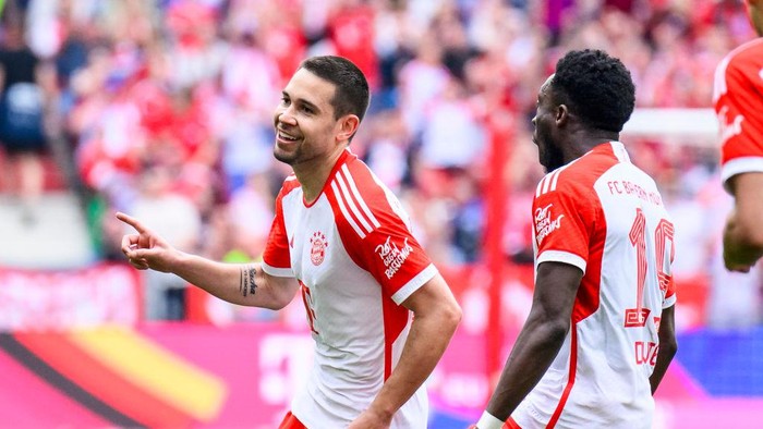 13 April 2024, Bavaria, Munich: Soccer: Bundesliga, Bayern Munich - 1. FC Köln, Matchday 29, Allianz Arena. Munichs Raphael Guerreiro (l) celebrates after his goal for 1:0 with Munichs Alphonso Davies (r). Photo: Tom Weller/dpa - IMPORTANT NOTE: In accordance with the regulations of the DFL German Football League and the DFB German Football Association, it is prohibited to utilize or have utilized photographs taken in the stadium and/or of the match in the form of sequential images and/or video-like photo series. (Photo by Tom Weller/picture alliance via Getty Images)