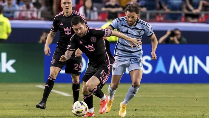 Inter Miami forward Lionel Messi (10) attempts to bypass Sporting Kansas City defender Tim Leibold, right, during the first half of an MLS soccer match Saturday, April 13, 2024, in Kansas City, Mo. (AP Photo/Nick Tre. Smith)
