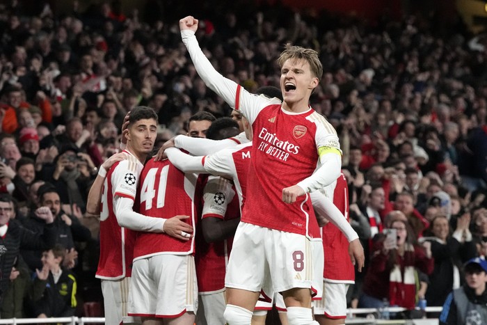 Arsenals Martin Odegaard, center, celebrates after Bukayo Saka scored the opening goal during the Champions League quarter final first leg soccer match between Arsenal and Bayern Munich at the Emirates Stadium, London, Tuesday, April 9, 2024. (AP Photo/Frank Augstein)
