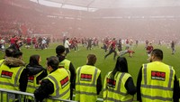 Suporter Bayer Leverkusen berlarian kegirangan di lapangan BayArena, diamati para steward pertandingan. Foto: AP/Martin Meissner
