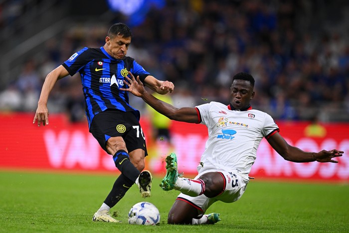 MILAN, ITALY - APRIL 14: Alexis Sanchez of FC Internazionale, in action, is challenged during the Serie A TIM match between FC Internazionale and Cagliari at Stadio Giuseppe Meazza on April 14, 2024 in Milan, Italy. (Photo by Mattia Ozbot - Inter/Inter via Getty Images)