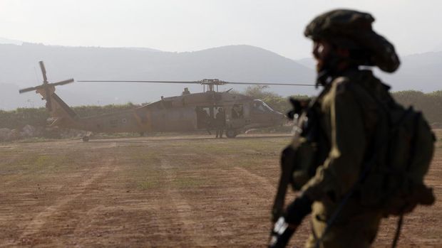 Seorang tentara Israel melihat helikopter lepas landas saat latihan militer di Galilea Atas dekat perbatasan Lebanon pada 7 Februari 2024, di tengah pertempuran yang sedang berlangsung antara Israel dan militan Hamas Palestina di Jalur Gaza.  (Foto oleh Jalaa MAREY / AFP)