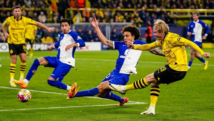 DORTMUND, GERMANY - APRIL 16:  Julian Brandt of Borussia Dortmund shoots to score his teams first goal as Axel Witsel of Atletico Madrid tries to block during the UEFA Champions League quarter-final second leg match between Borussia Dortmund and Atletico Madrid at Signal Iduna Park on April 16, 2024 in Dortmund, Germany.  (Photo by Rene Nijhuis/MB Media/Getty Images)