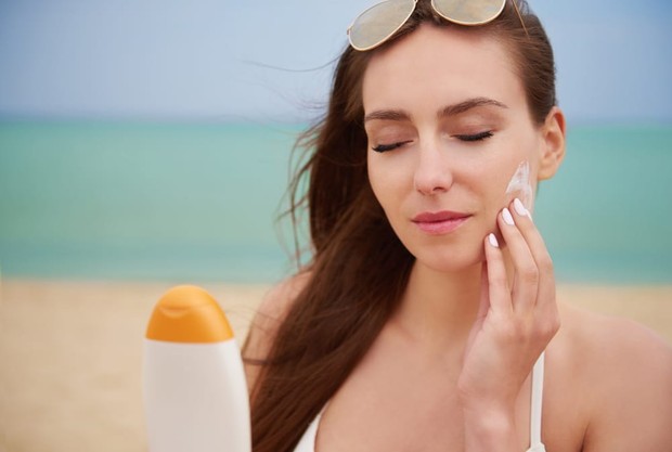 Seorang perempuan memakai sunscreen