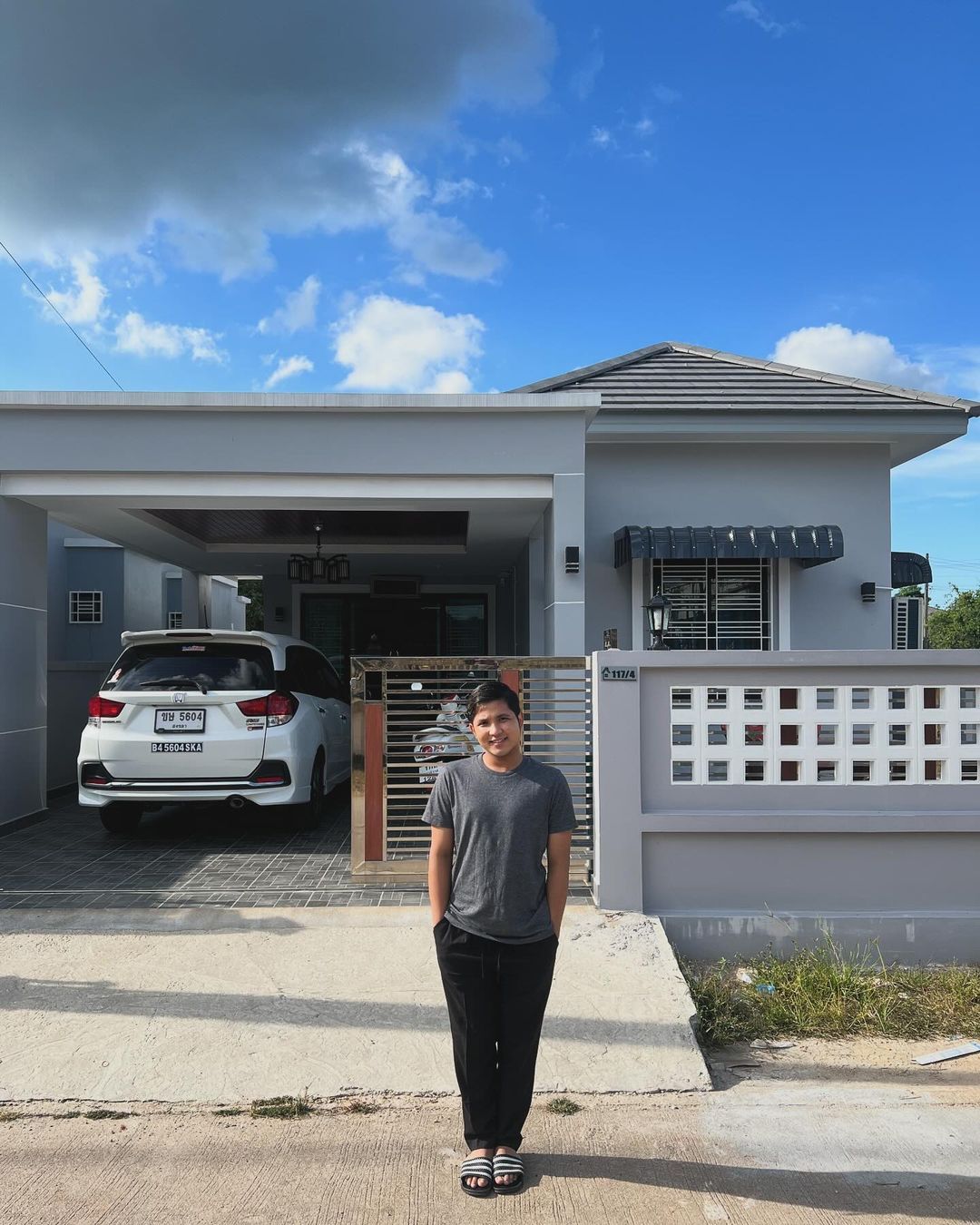 Jirayut berfoto di depan rumah barunya di Thailand.