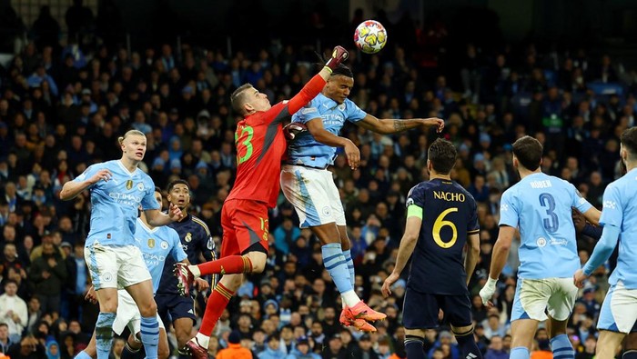Soccer Football - Champions League - Quarter Final - Second Leg - Manchester City v Real Madrid - Etihad Stadium, Manchester, Britain - April 17, 2024 Real Madrids Andriy Lunin in action with Manchester Citys Manuel Akanji REUTERS/Molly Darlington