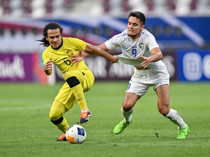 Ulugbek Khoshimov (R) from Uzbekistan is battling for the ball with Muhammad Naimudin Akmal (L) from Malaysia during the AFC U23 Asian Cup Qatar 2024 Group D match between Uzbekistan and Malaysia at Khalifa International Stadium in Doha, Qatar, on April 17, 2024. (Photo by Noushad Thekkayil/NurPhoto via Getty Images)