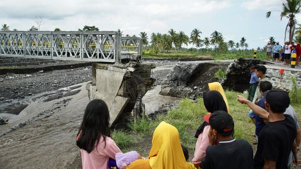 Warga mengamati kondisi Jembatan Mujur II yang rusak di Lumajang, Jawa Timur, Jumat (19/4/2024). Jembatan penghubung Desa Kloposawit dan Desa Tumpeng tersebut putus akibat diterang banjir lahar hujan Gunung Semeru pada Kamis (18/4). ANTARA FOTO/Irfan Sumanjaya/aww.