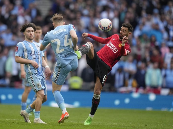 Manchester Uniteds Bruno Fernandes, right, challenges for the ball with Coventry Citys Matthew James Godden during the English FA Cup semifinal soccer match between Coventry City and Manchester United at Wembley stadium in London, Sunday, April 21, 2024. (AP Photo/Alastair Grant)