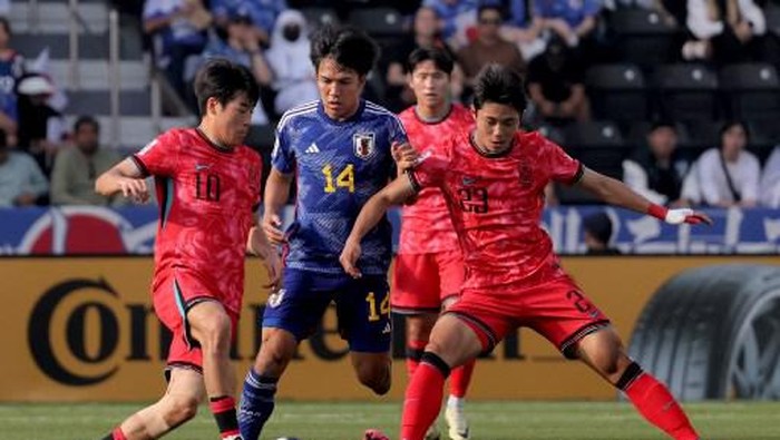 Japans midfielder #14 Satoshi Tanaka vies against South Koreas midfielder #23 Dong-Jin Kim and defender #10 Hong Yun-sang for the ball during the AFC U23 Asian Cup Qatar 2024 Group B match between Korea and Japan at Jassim Bin Hamad Stadium in Doha on April 22, 2024. (Photo by KARIM JAAFAR / AFP)