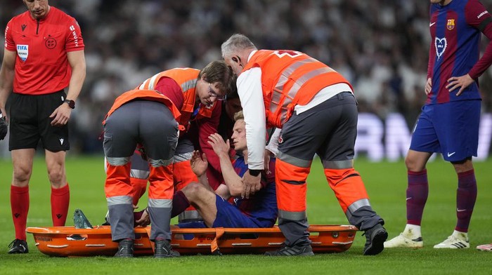 Barcelonas Frenkie de Jong reacts after getting injured during the Spanish La Liga soccer match between Real Madrid and Barcelona at the Santiago Bernabeu stadium in Madrid, Spain, Sunday, April 21, 2024. (AP Photo/Manu Fernandez)