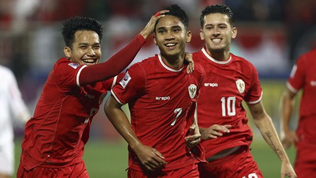 Indonesia's midfielder #07 Marselino Ferdinan celebrates with teammates after scoring his team's first goal in a penalty shot during their AFC U23 Asian Cup Group A match against Jordan at Abdullah Bin Khalifa Stadium in Doha on April 21, 2024. (Photo by KARIM JAAFAR / AFP)