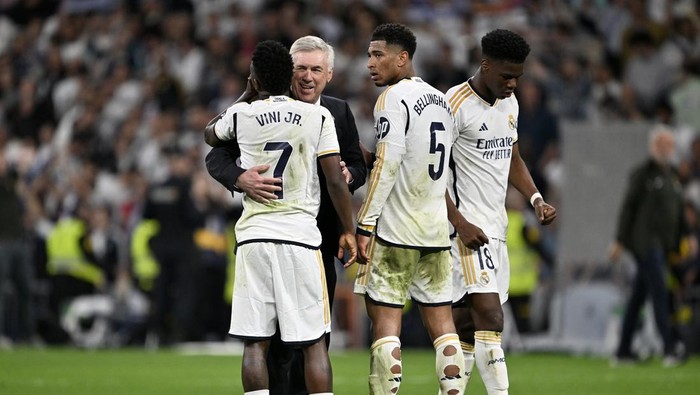 MADRID, SPAIN - APRIL 21: Jude Bellingham (2nd R), Aurelien Tchouameni (R), Vinicius Junior (L) and head coach Carlo Ancelotti (2nd L) of Real Madrid celebrate their victory at the end of the La Liga 32nd week football match between Real Madrid and Barcelona at Santiago Bernabeu Stadium in Madrid, Spain on April 21, 2024. (Photo by Burak Akbulut/Anadolu via Getty Images)