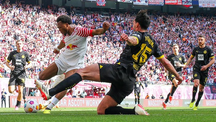 27 April 2024, Saxony, Leipzig: Soccer: Bundesliga, RB Leipzig - Borussia Dortmund, Matchday 31, Red Bull Arena. Leipzigs Lois Openda (l) and Dortmunds Mats Hummels fight for the ball. IMPORTANT NOTE: In accordance with the regulations of the DFL German Football League and the DFB German Football Association, it is prohibited to use or have used photographs taken in the stadium and/or of the match in the form of sequential images and/or video-like photo series. Photo: Jan Woitas/dpa (Photo by Jan Woitas/picture alliance via Getty Images)