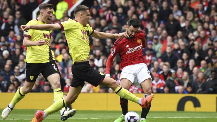Manchester Uniteds Bruno Fernandes, right, attempts a shot on goal challenged by Burnleys Maxime Esteve, center, and Dara OShea during the English Premier League soccer match between Manchester United and Burnley at Old Trafford stadium in Manchester, England, Saturday, April 27, 2024. (AP Photo/Rui Vieira)