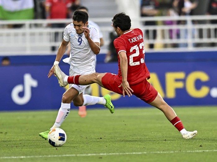 Abdurauf Buriev (L) of Uzbekistan   is battling for the ball with Marcelino Ferdinan of Indonesia during the AFC U23 Asian Cup Qatar 2024 Semi Final match between Indonesia and Uzbekistan at Abdullah Bin Khalifa Stadium in Doha, Qatar, on April 29, 2024. 



 (Photo by Noushad Thekkayil/NurPhoto via Getty Images)