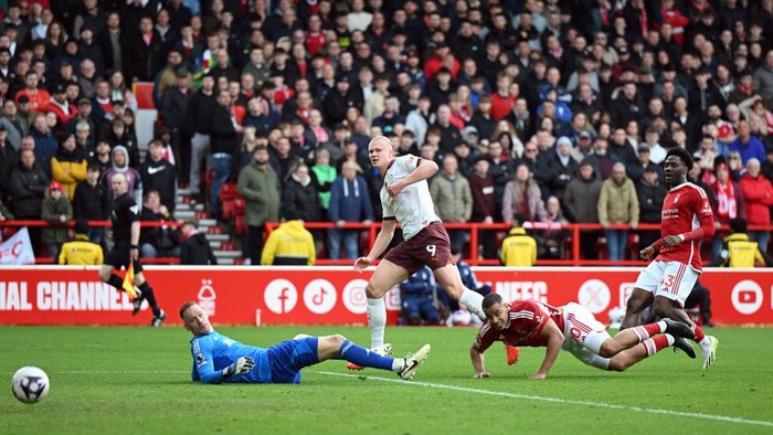 NOTTINGHAM, ENGLAND - APRIL 28: Erling Haaland of Manchester City scores his team's second goal past Matz Sels of Nottingham Forest during the Premier League match between Nottingham Forest and Manchester City at City Ground on April 28, 2024 in Nottingham, England. (Photo by Michael Regan/Getty Images)