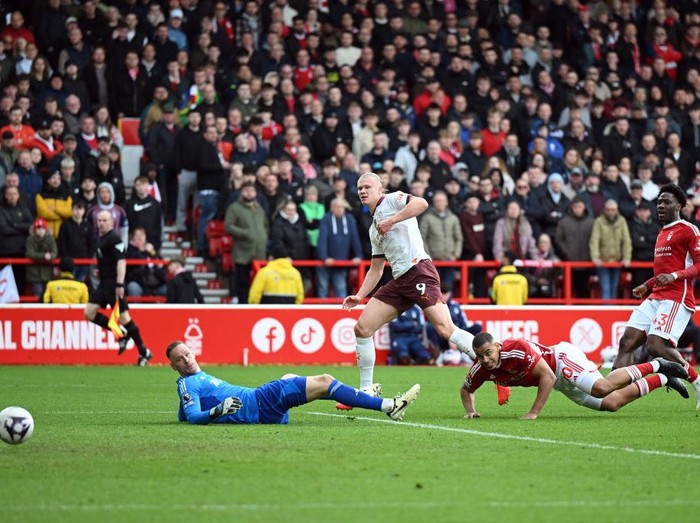 NOTTINGHAM, ENGLAND - APRIL 28: Erling Haaland of Manchester City scores his team's second goal past Matz Sels of Nottingham Forest during the Premier League match between Nottingham Forest and Manchester City at City Ground on April 28, 2024 in Nottingham, England. (Photo by Michael Regan/Getty Images)