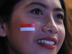 Seorang perempuan memasang stiker bendera merah putih di pipinya saat nonton bareng pertandingan Timnas Indonesia U-23 melawan Timnas Uzbekistan U-23 di Gedung Dharma Negara Alaya, Denpasar, Bali, Senin (29/4/2024). ANTARA FOTO/Nyoman Hendra Wibowo