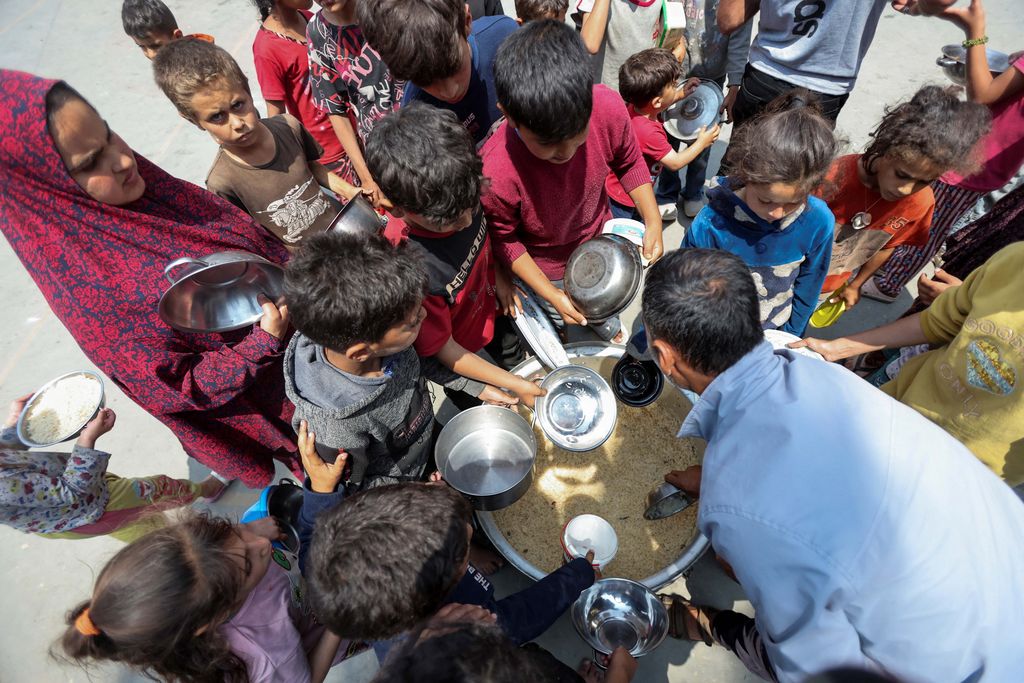 Palestinians gather to receive food meals cooked by World Central Kitchen (WCK) after the charity resumed operations, at a school sheltering displaced people, amid the ongoing conflict between Israel and Hamas, in Deir Al-Balah in the central Gaza Strip May 1, 2024. REUTERS/Ramadan Abed