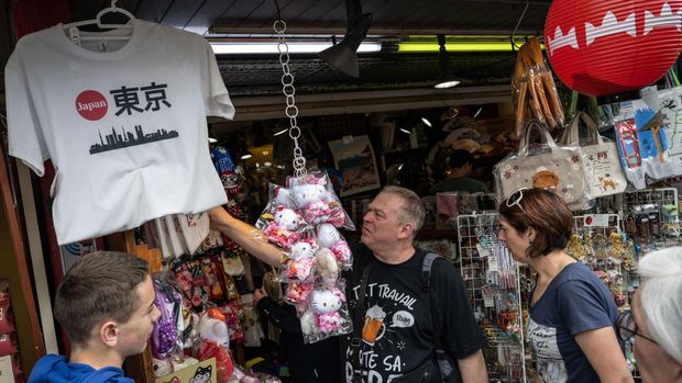 Tourists shop at a souvenir store on Nakamise shopping street near Sensoji Temple in Tokyo on April 30, 2024. (Photo by Yuichi YAMAZAKI / AFP)