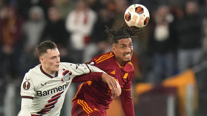 Romas Chris Smalling, right, challenges for the ball with Leverkusens Florian Wirtz during the Europa League semifinal first leg soccer match between Roma and Bayer Leverkusen at Romes Olympic Stadium, Italy, Thursday, May 2, 2024. (AP Photo/Alessandra Tarantino)