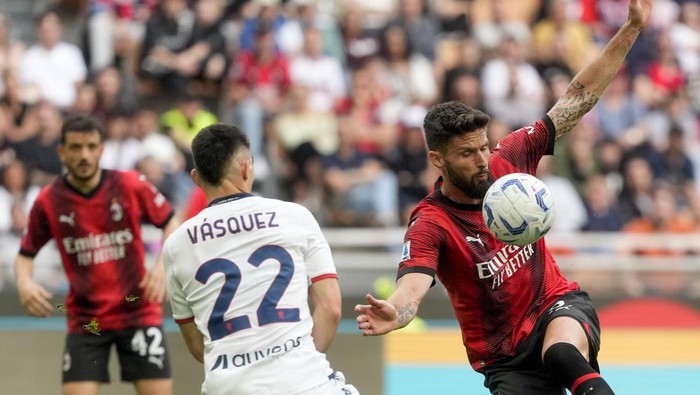 AC Milans Olivier Giroud, right, duels for the ball with Genoas Johan Vasquez during a Serie A soccer match between AC Milan and Genoa, at the San Siro stadium in Milan, Italy, Sunday, May 5, 2024. (AP Photo/Luca Bruno)